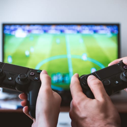 Zwei Personen spielen FIFA auf der PS4